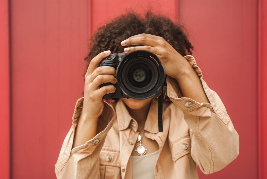 young african american woman using digital camera on street